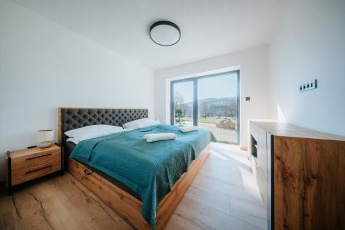 a bedroom with a bed and a large window at Kotva By Momoland - Apartmán in Ružiná