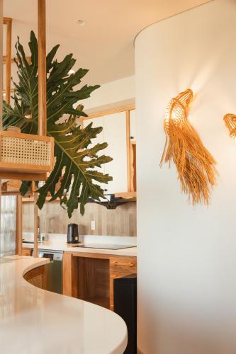 a kitchen with a white table and a plant on the wall at La Brise in Ấp Khánh Phước (1)