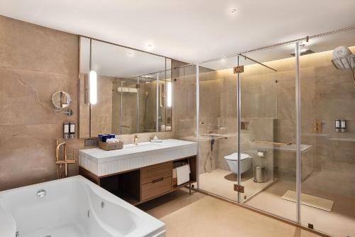 a bathroom with a tub and a sink and a shower at Fortune Select Siliguri- Member ITC Hotels' Group in Siliguri