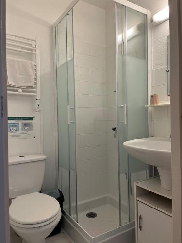 a bathroom with a toilet and a glass shower at Hôtel Olydea Les Epesses - à 2,5km du PuyDuFou in Les Épesses