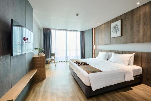 a hotel room with a large bed and a desk at TK Palace Hotel & Convention Bangkok in Bangkok