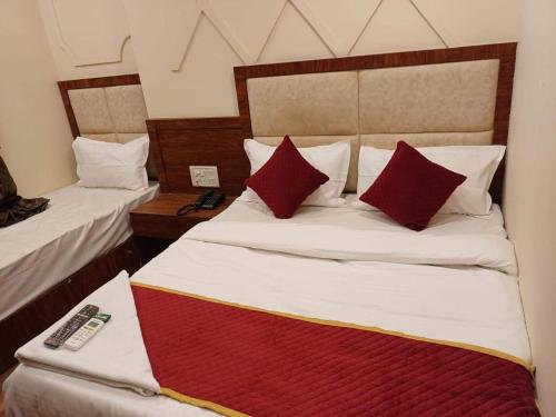 a bedroom with two beds with red pillows at Hotel Ashirwad Inn in Mumbai