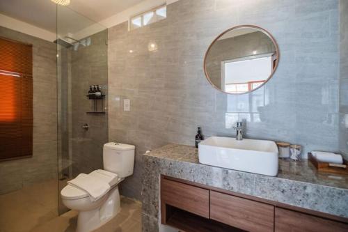 a bathroom with a toilet and a sink and a mirror at Villa OG Cruz in Canggu