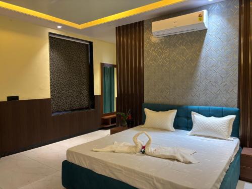a bedroom with a bed with two swans on it at Hotel Golchi Palace in Lālsot
