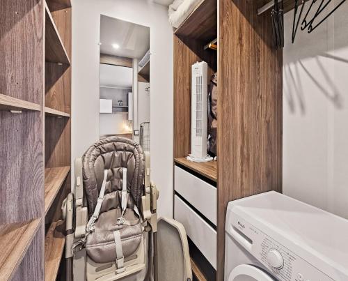 a stroller in a laundry room with a washer and dryer at Le Coin Chill in Litteau