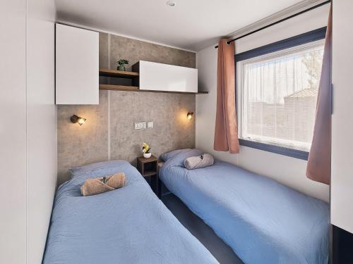 two beds in a small room with a window at Le Coin Chill in Litteau