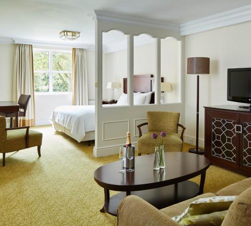 a hotel room with a bed and a living room at Sprowston Manor Hotel, Golf & Country Club in Norwich