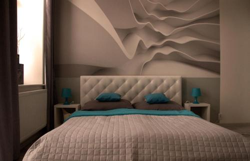 a bedroom with a bed with a mountain mural on the wall at Apartment Centrum number 8 in Poprad
