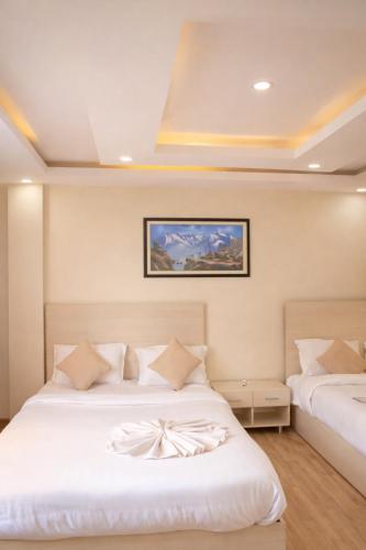 a bedroom with two beds with white sheets at Thamel Central Apartment in Kathmandu