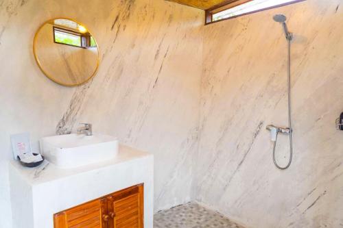 a bathroom with a sink and a shower with a mirror at นวนิยาย Nava-Niyay in Ban Huai Ti