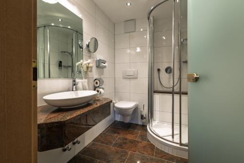 a bathroom with a sink and a toilet and a shower at Bloberger Hof in Salzburg