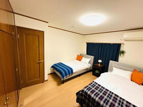 a hotel room with two beds and a window at 清場Kiyoba in Kawaguchi