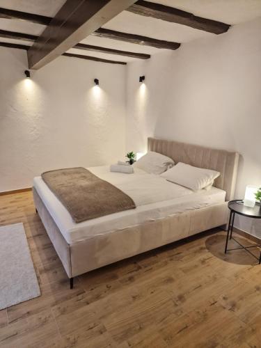 a bedroom with a large bed and a table at Old City Apartment Möckmühl in Möckmühl