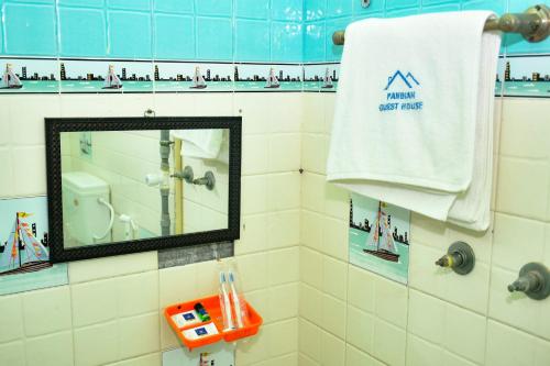 a mirror in a bathroom with a white towel at Pandiyan guest house in Madurai