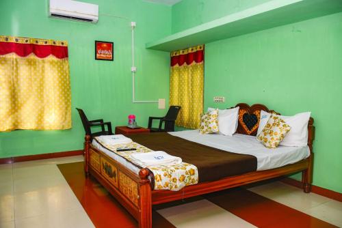 a bedroom with a bed with green walls at Pandiyan guest house in Madurai