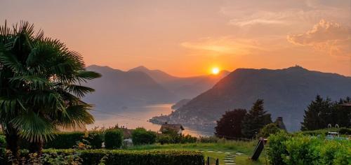 a view of the sun setting over a mountain at CasaDolcelago Sulzano Villa con Giardino Vista Lago Parking Free in Sulzano