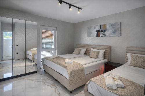 a bedroom with two beds and a walk in shower at DINLUX Luxury Apartment in Maribor
