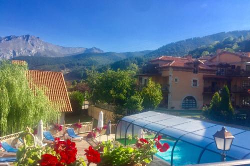a view of a resort with a swimming pool and mountains at Apartamentos Alquitara in Potes