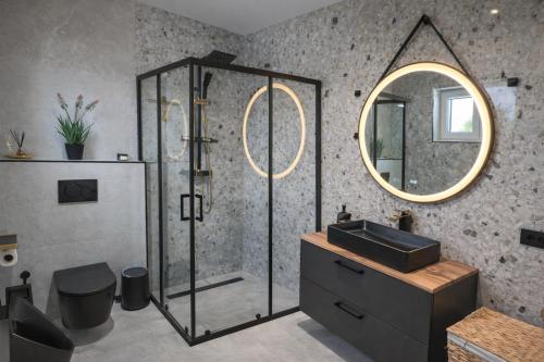 a bathroom with a shower and a sink and a mirror at DINLUX Luxury Apartment in Maribor