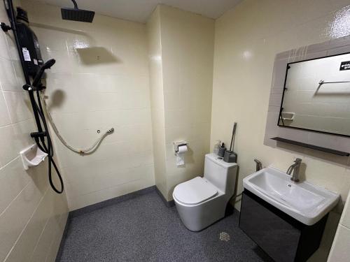 a bathroom with a white toilet and a sink at The Regency PortDickson A1-6 in Port Dickson