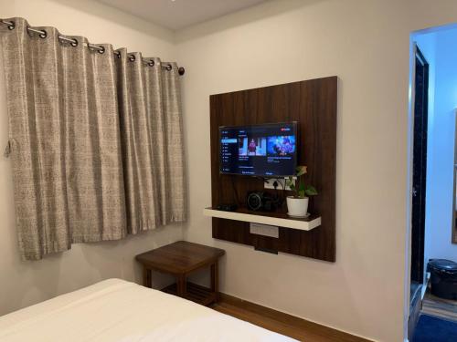 a bedroom with a tv on a wall at Dayanand Residency in Chitradurga