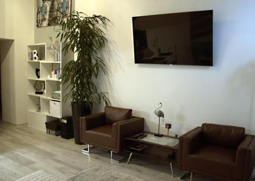 a living room with two chairs and a flat screen tv at Apartment Centrum number 8 in Poprad