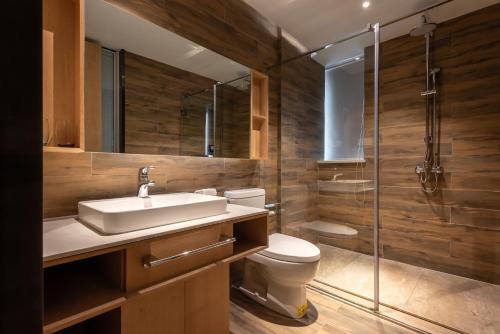 a bathroom with a toilet and a sink and a shower at 两江万励OneJasper空中江景酒店 in Chongqing