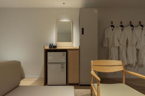 a room with a mirror and a chair and a refrigerator at Anook Hotel Jungangro Station in Daejeon