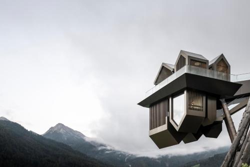 ein Haus an einem Berghang in der Unterkunft Hotel Hubertus in Olang