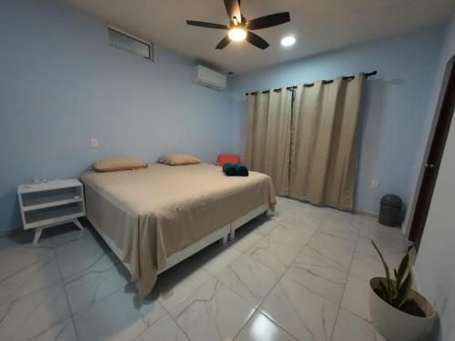 a bedroom with a bed and a ceiling fan at Casa ilusion Tuxpan Veracruz in Tampamachoco