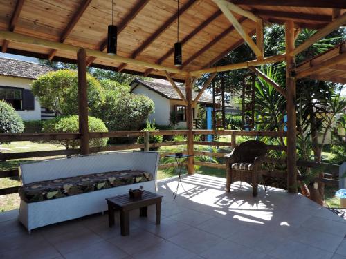 a wooden pergola with a bench and a table at Pousada Mares do Santinho in Florianópolis