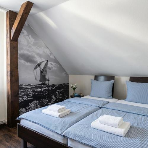 a bedroom with two beds and a painting on the wall at Hotel Marín in Steinhude