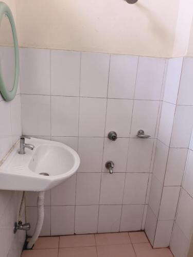 a white bathroom with a sink and a mirror at Hotel Silver Dragon, NK Darranga in Darranga