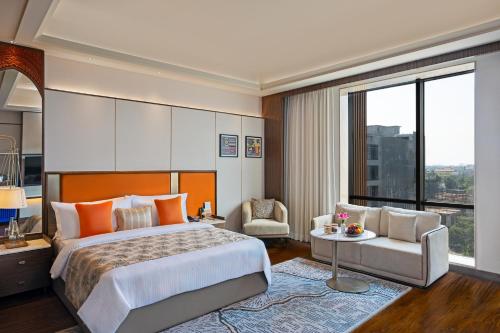 a bedroom with a large bed and a large window at Fortune Select Siliguri- Member ITC Hotels' Group in Siliguri