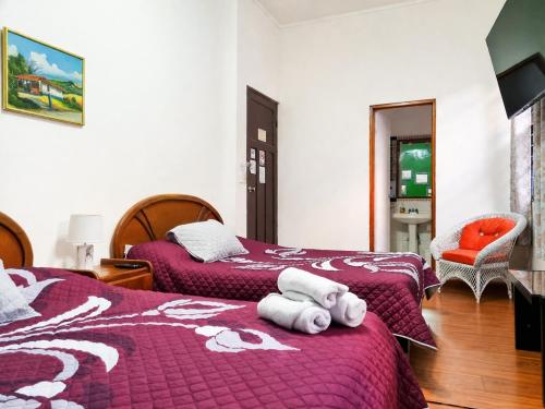 a hotel room with two beds with towels on them at Hotel 1492 in San José