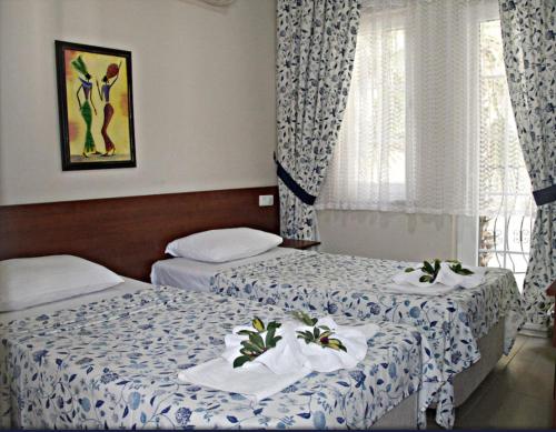 two beds in a hotel room with towels on them at So Dalyan in Ortaca
