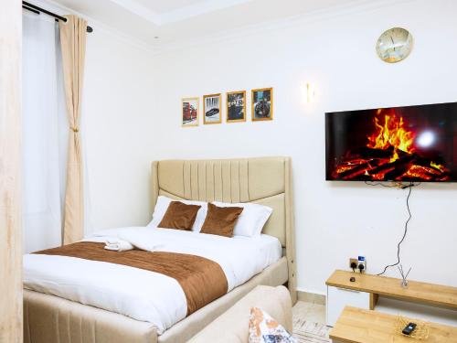 a bedroom with a bed and a tv on a wall at Epitome Luxe Homes near UN Gigiri and Two Rivers Mall in Ruaka
