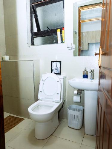 a bathroom with a toilet and a sink at Epitome Luxe Homes near UN Gigiri and Two Rivers Mall in Ruaka