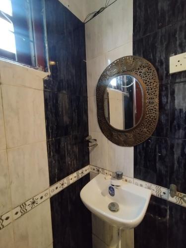 a bathroom with a sink and a mirror at NS Apartments in Dalugama