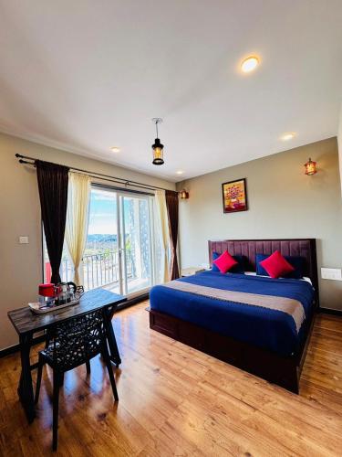 a bedroom with a bed and a table and a window at Everfreshhighviewcottage in Ooty
