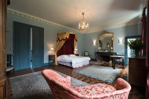 1 dormitorio con cama, silla y espejo en Château de tailly en Meursault