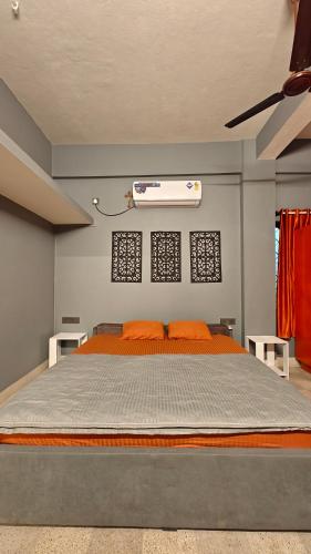 a bedroom with a large bed with orange pillows at Casa pinto Valencia and The Second Storey in Mangalore