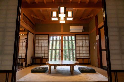 a room with a table in the middle of it at 24時間源泉かけ流しを ひとりじめできる 一棟貸しVilla安曇野 in Azumino