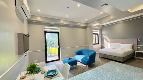 a hotel room with a bed and a desk at The Ancestry Suites in Wasig