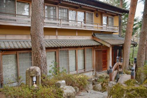 a house with a tree in front of it at 24時間源泉かけ流しを ひとりじめできる 一棟貸しVilla安曇野 in Azumino