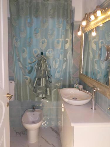a bathroom with a sink and a toilet and a mirror at Villa Angelina Garden in Grimaud