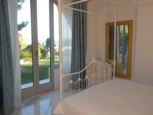 a bedroom with a canopy bed and a large window at Villa Angelina Garden in Grimaud