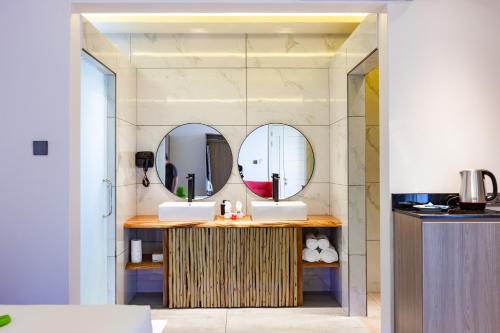 a bathroom with two sinks and two mirrors at Cote d'Or Retreat in Anse Volbert Village