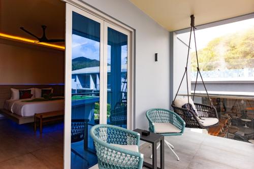 a room with a balcony with a bed and a swing at Cote d'Or Retreat in Anse Volbert Village