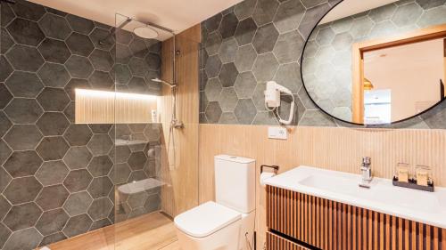 a bathroom with a toilet and a sink and a mirror at Sunset Suites by Bull Hotels in Puerto Rico de Gran Canaria